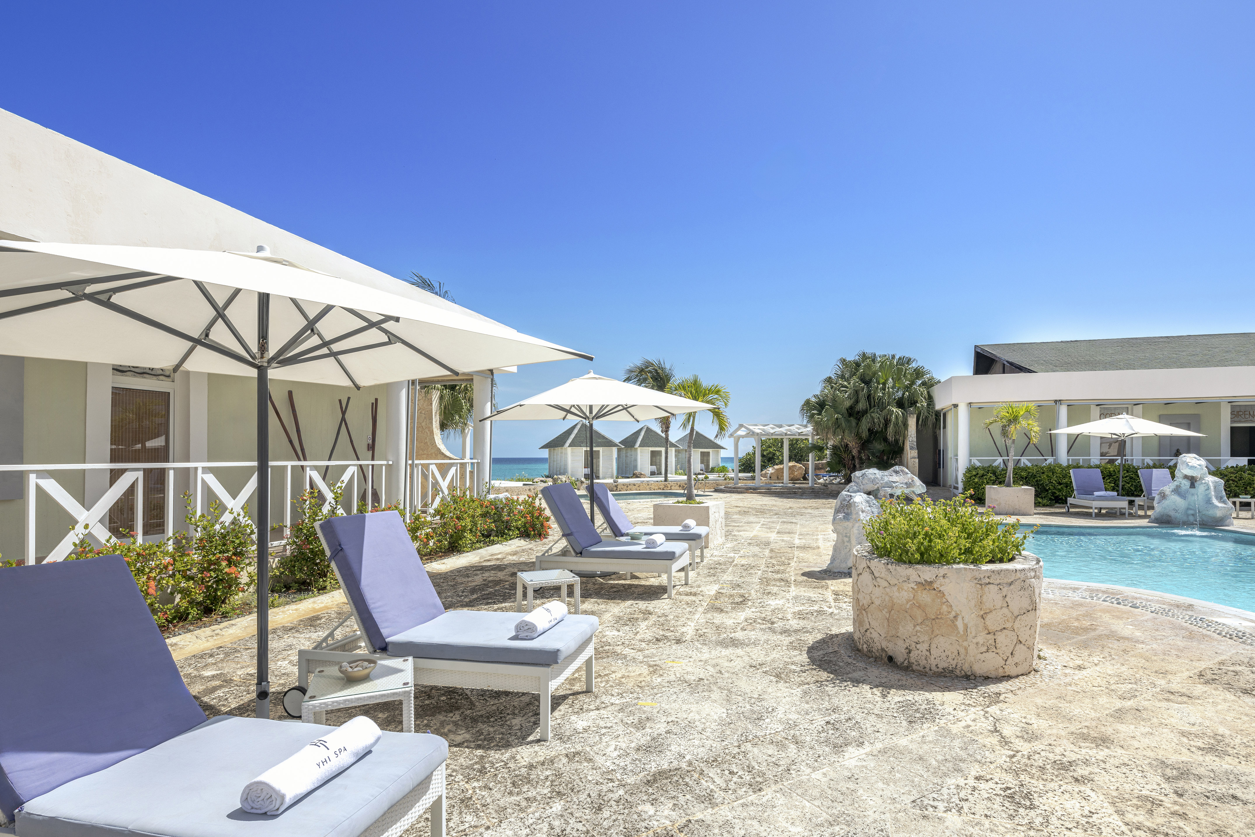 a pool with lounge chairs and umbrellas