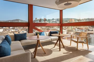 a room with a large window and a couch and chairs