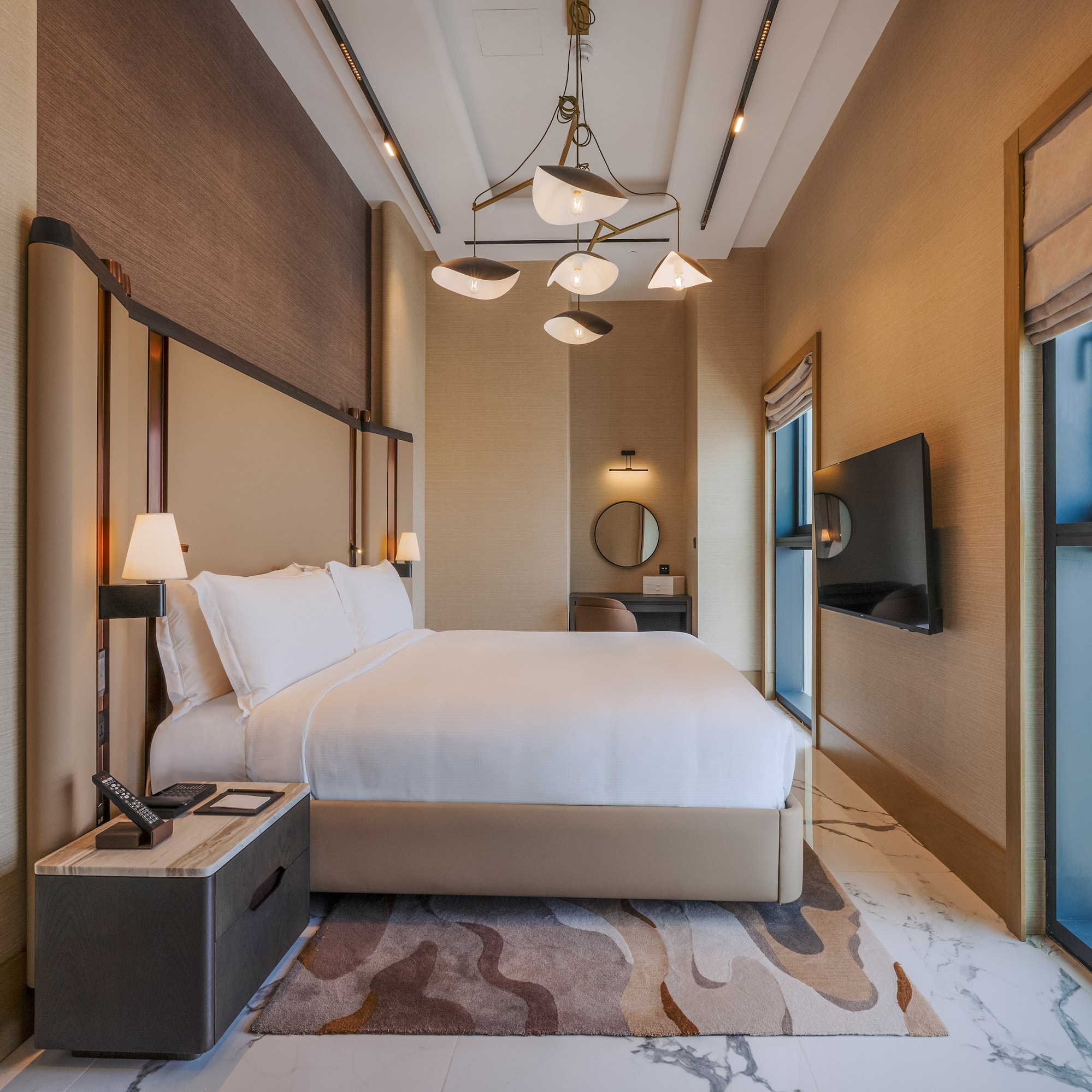 Luxury modern hotel bedroom with king bed and city view.