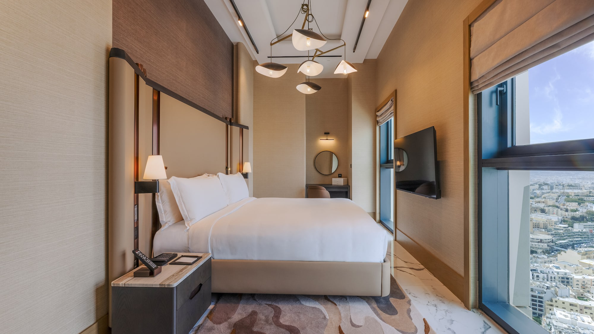 Luxury modern hotel bedroom with king bed and city view.