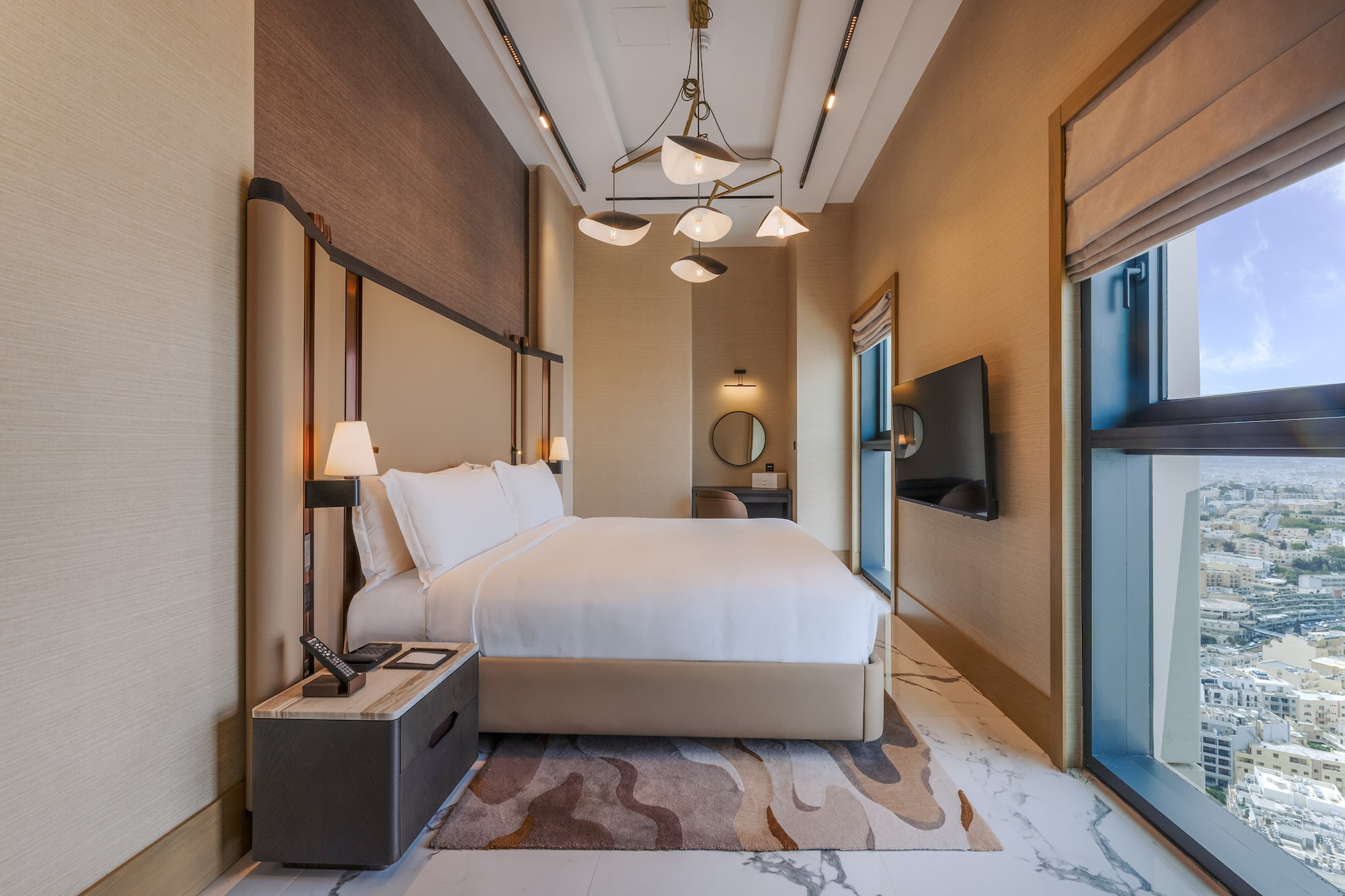 Luxury modern hotel bedroom with king bed and city view.