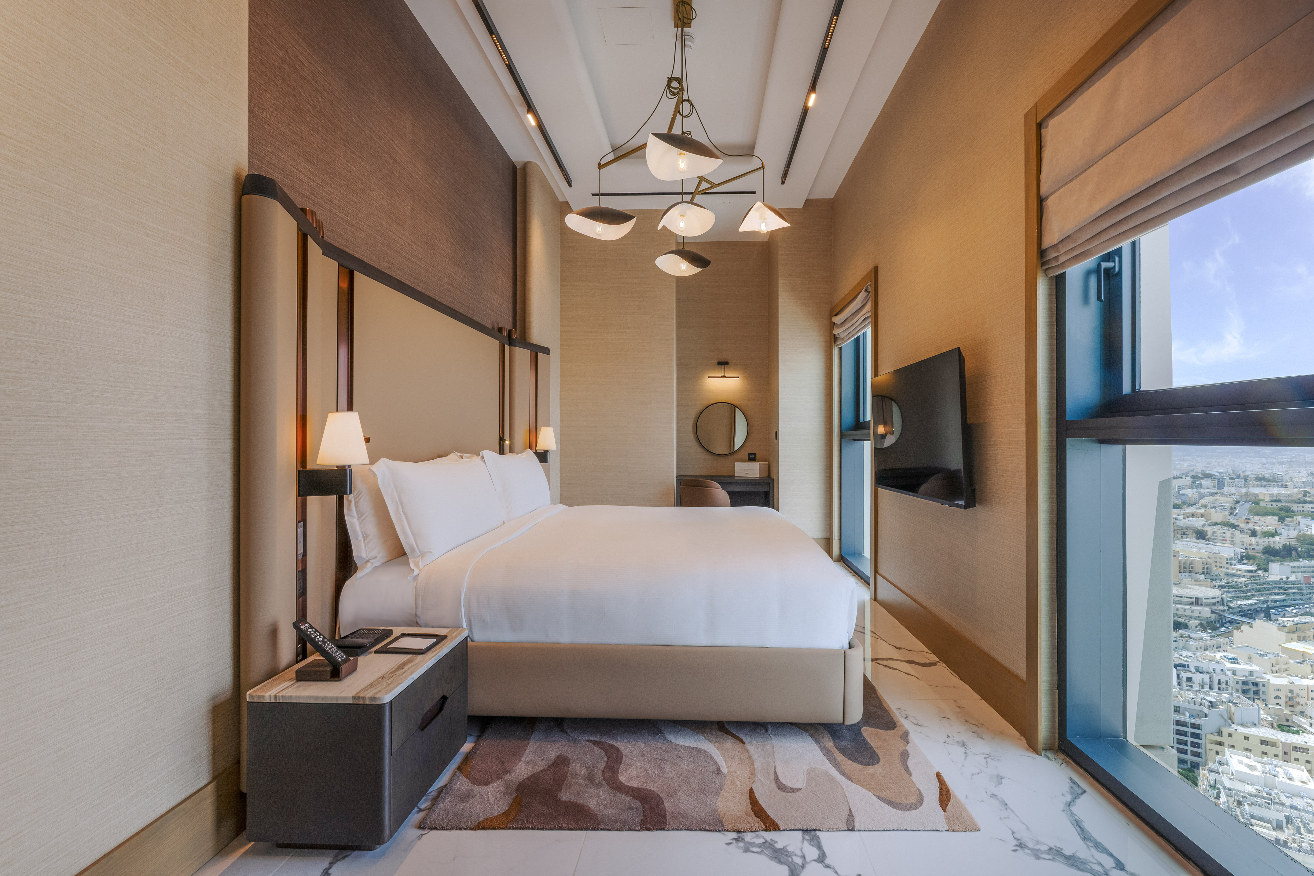 Luxury modern hotel bedroom with king bed and city view.