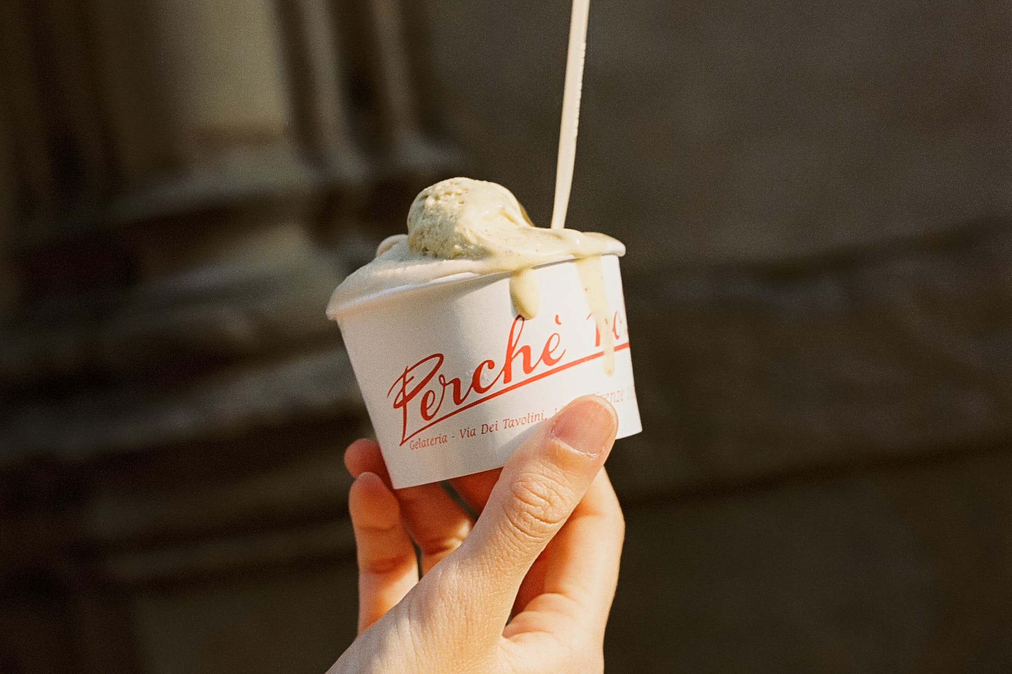 a hand holding a cup of ice cream