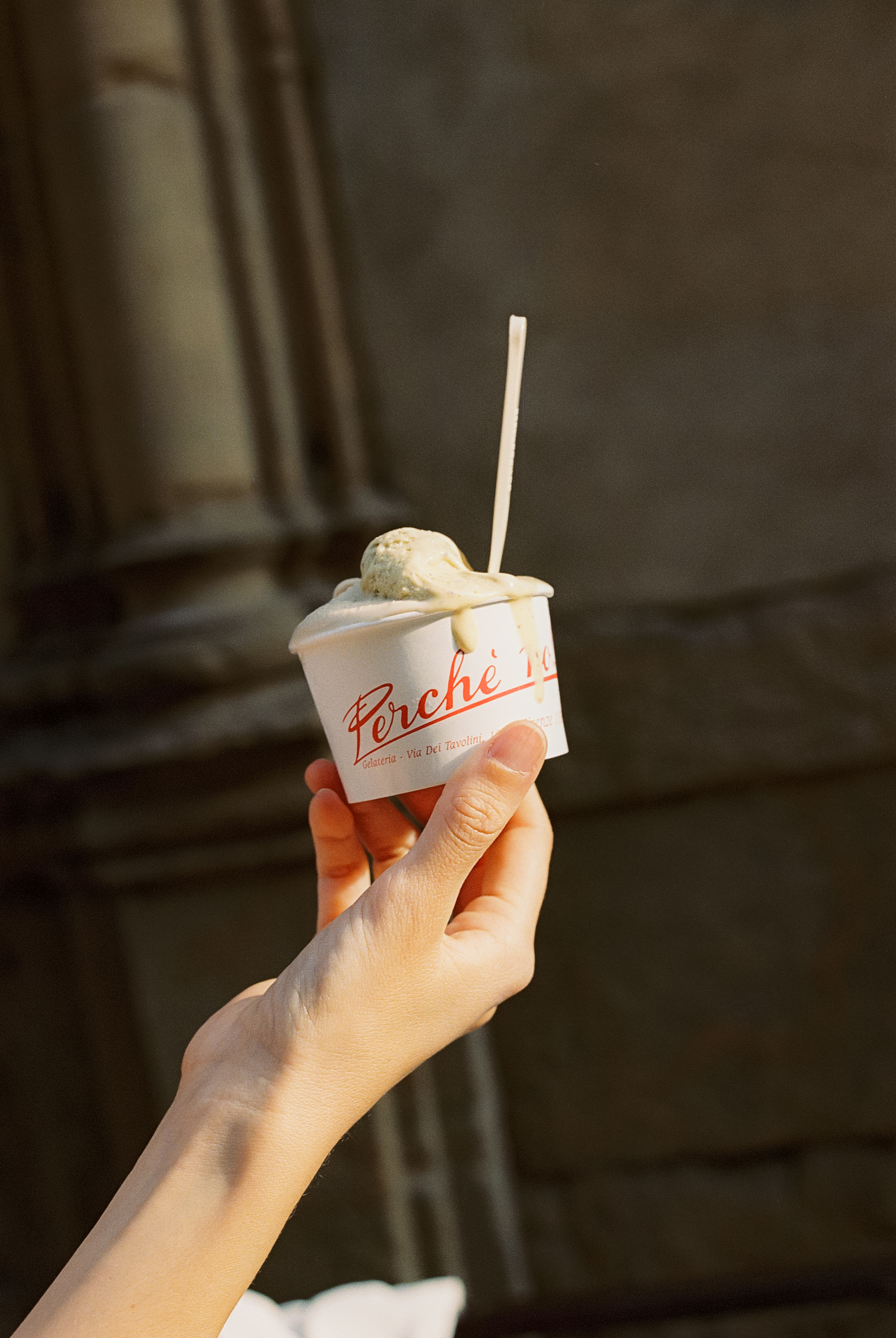 a hand holding a cup of ice cream