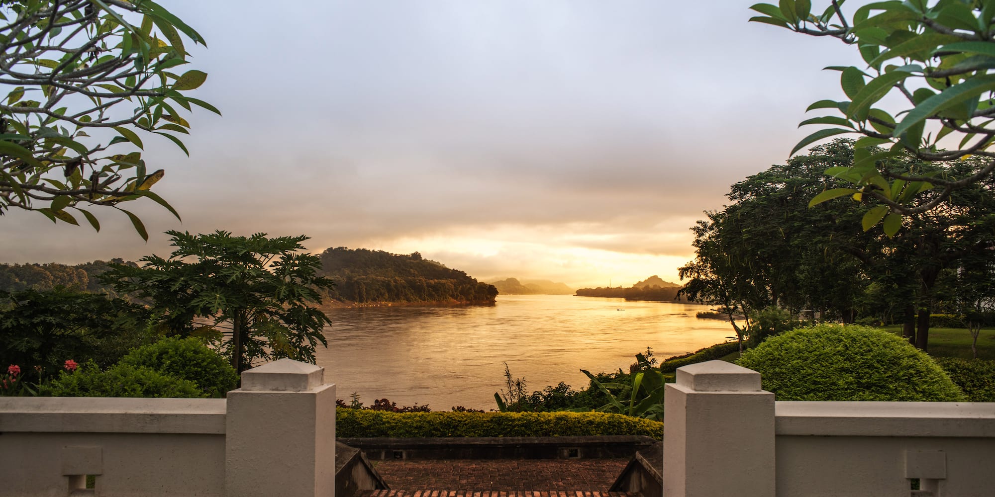 a brick walkway leading to a body of water