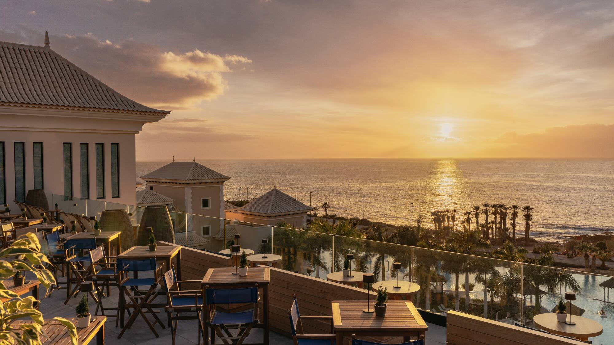 a restaurant with tables and chairs overlooking the ocean