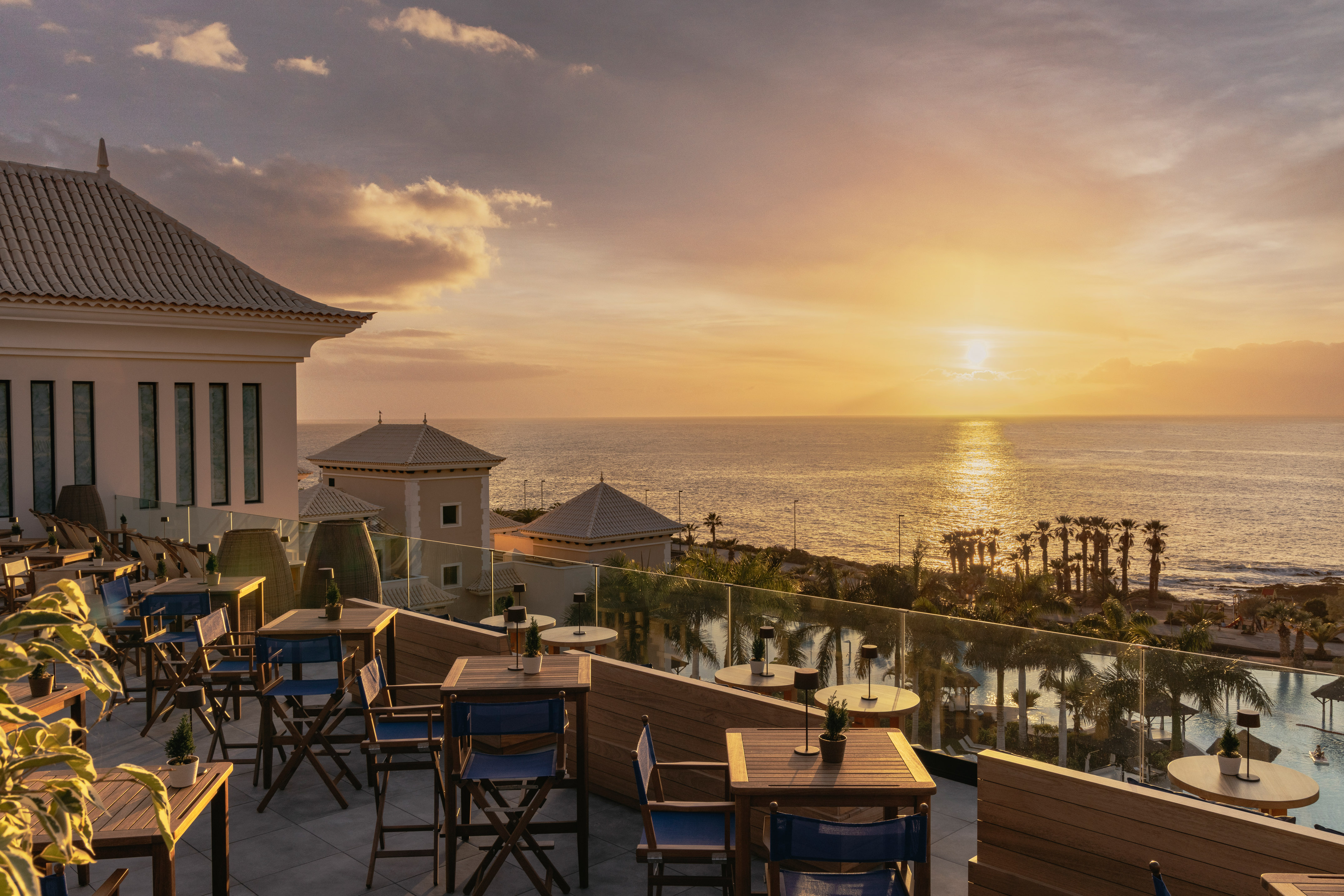 Terrace dining with sunset ocean views from a luxury resort.