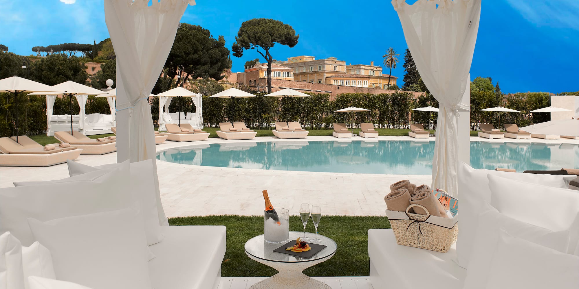 a white chairs and a table with a pool in the background