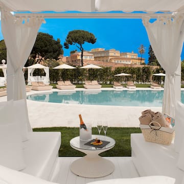 a white chairs and a table with a pool in the background