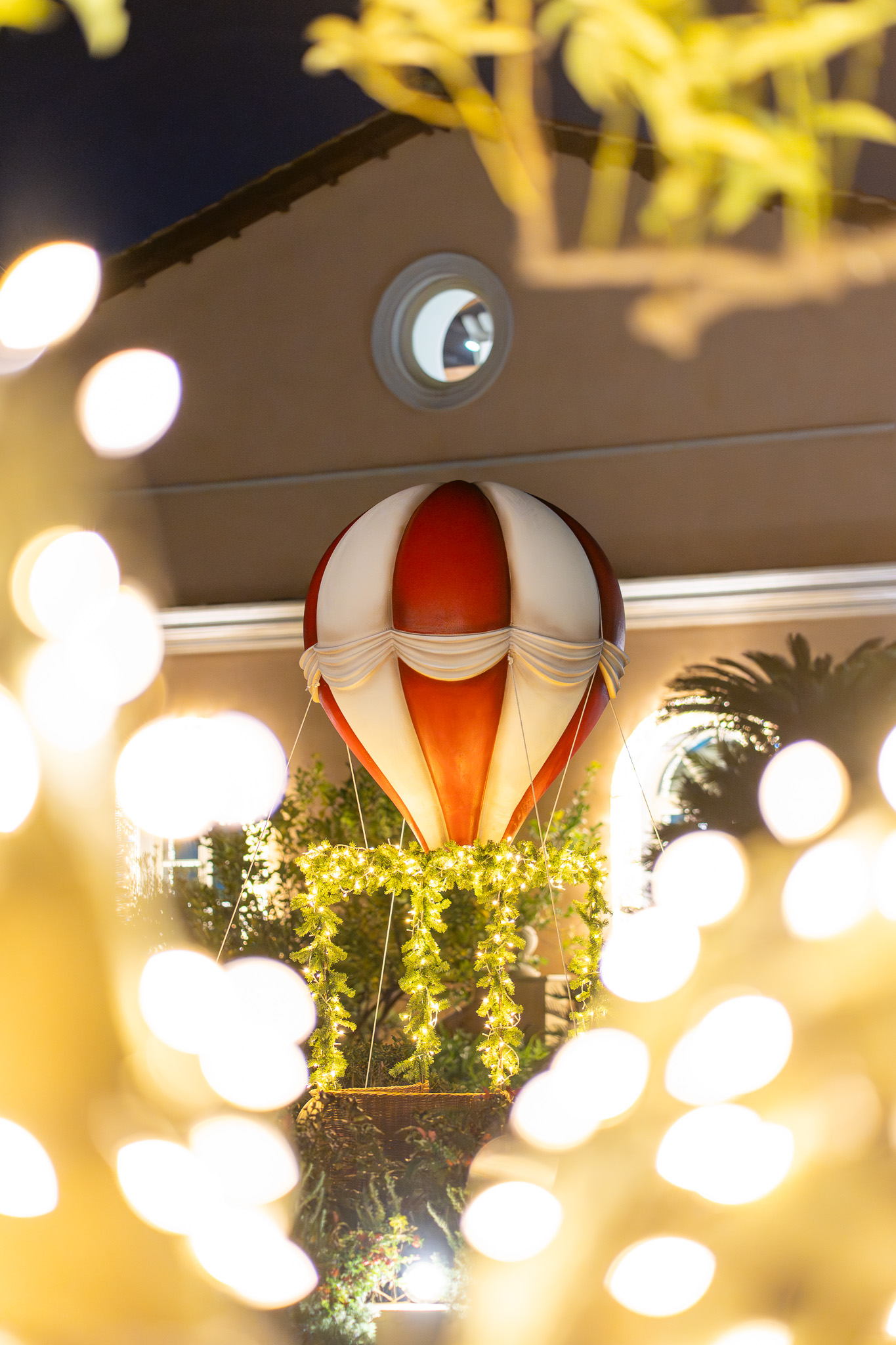 Red and white hot air balloon Christmas decoration with glowing lights.