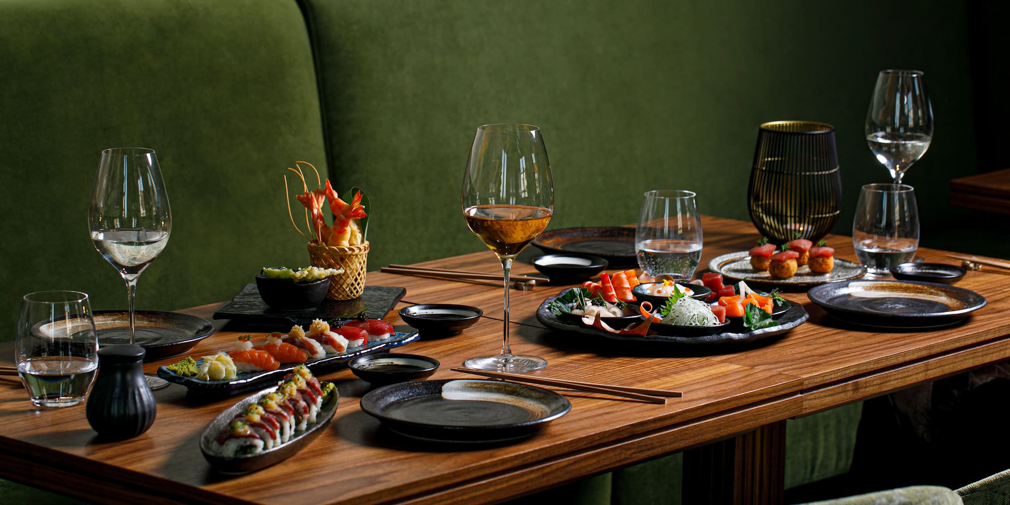 a table with plates of food and wine glasses