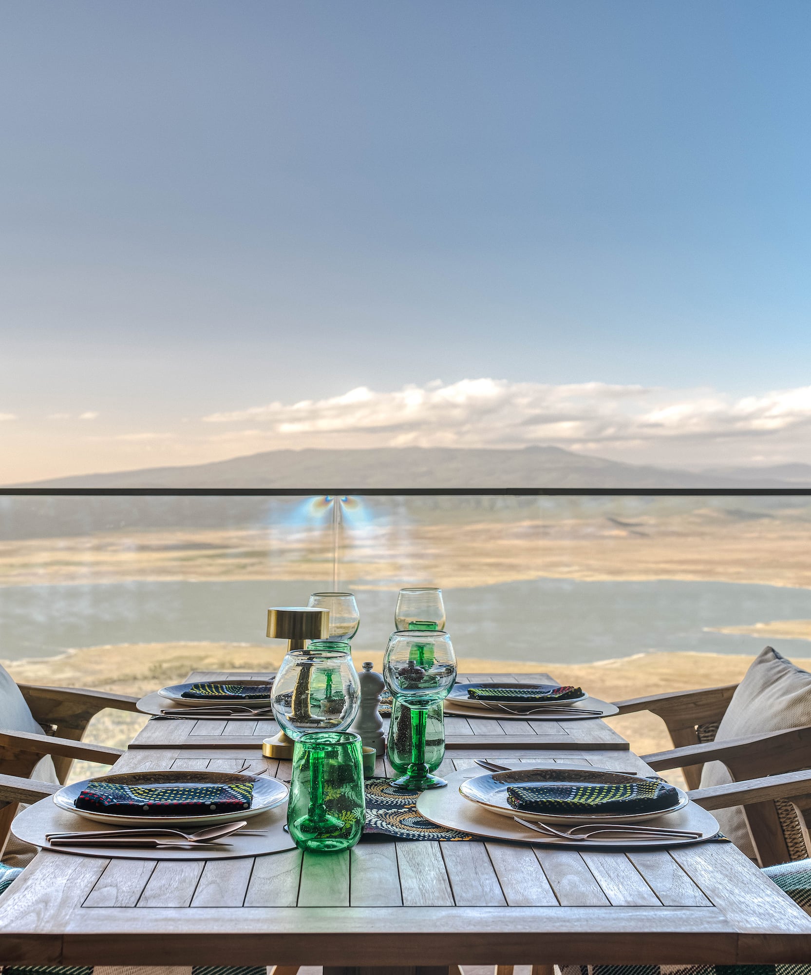 a table set for a dinner with a view of the ocean