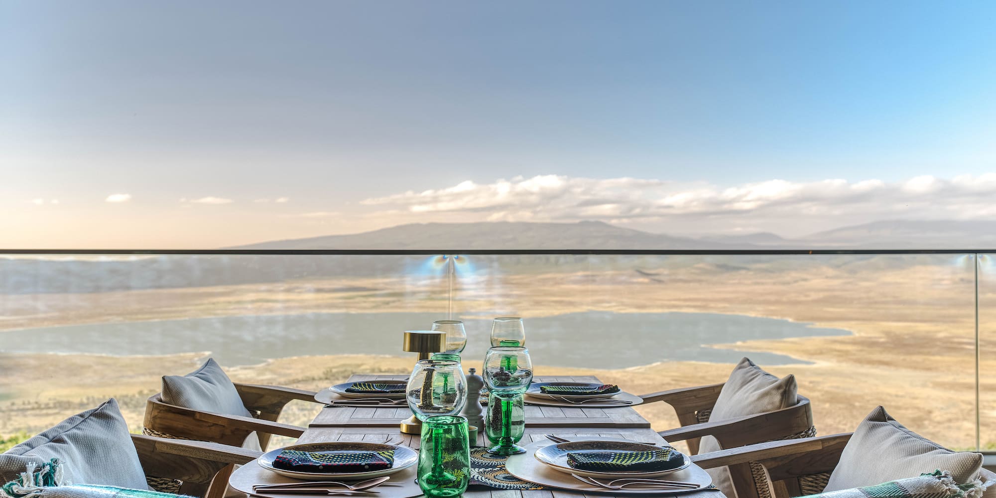 a table set for a dinner with a view of the ocean