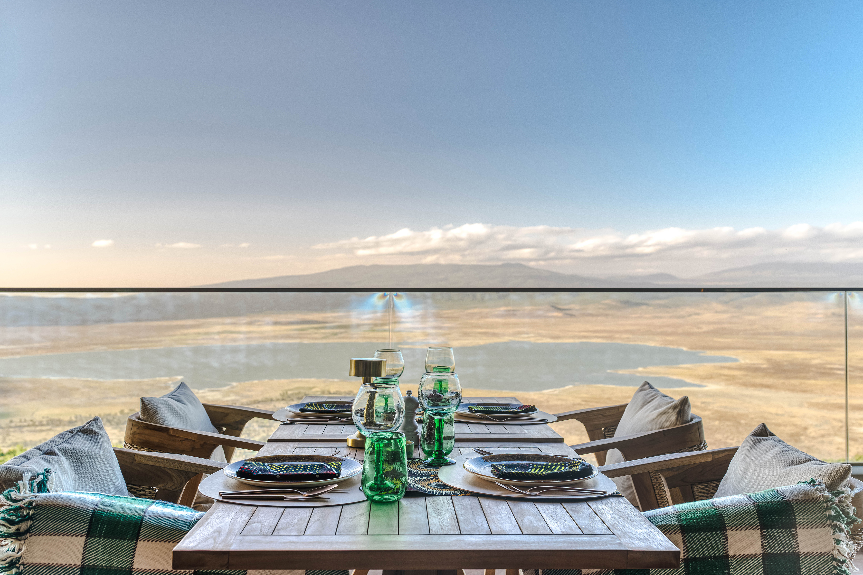 Luxury outdoor dining overlooking scenic lake and mountains.