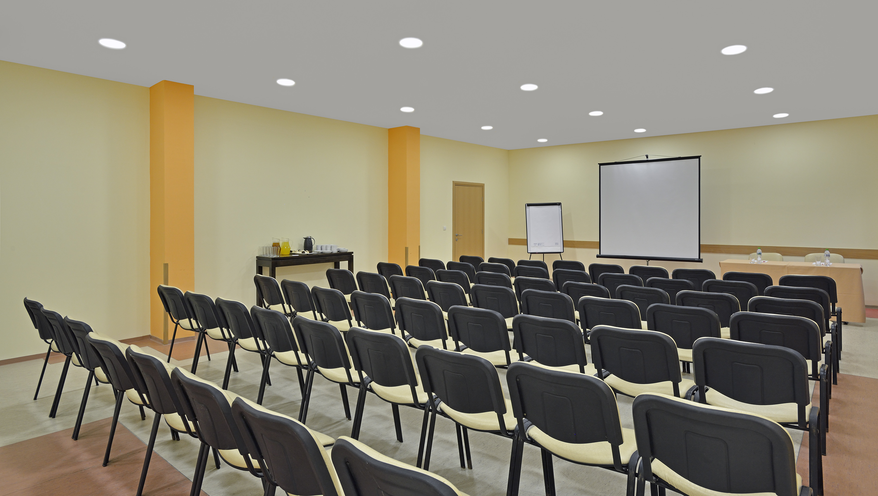 a room with rows of chairs and a projector screen