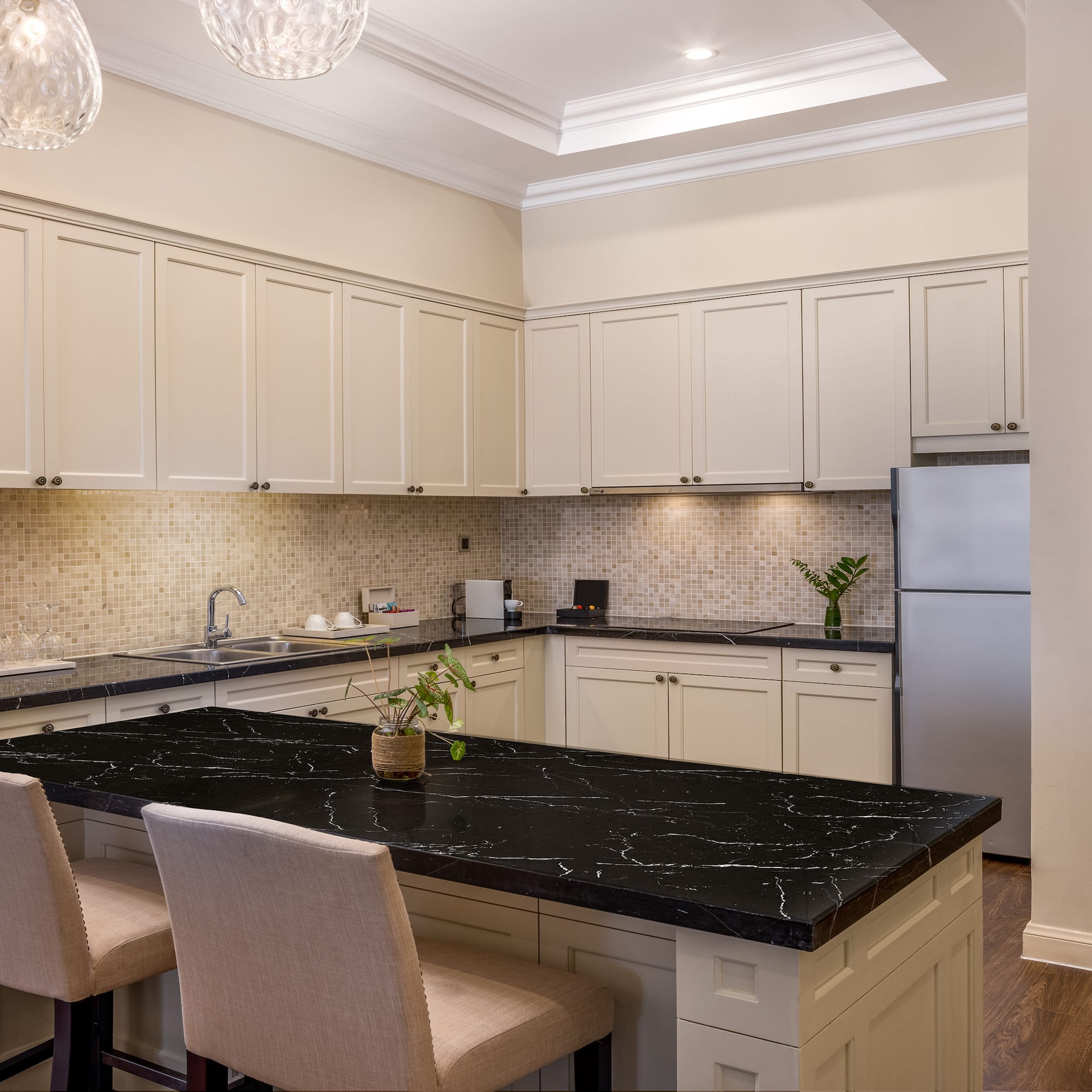 a kitchen with a black countertop and chairs