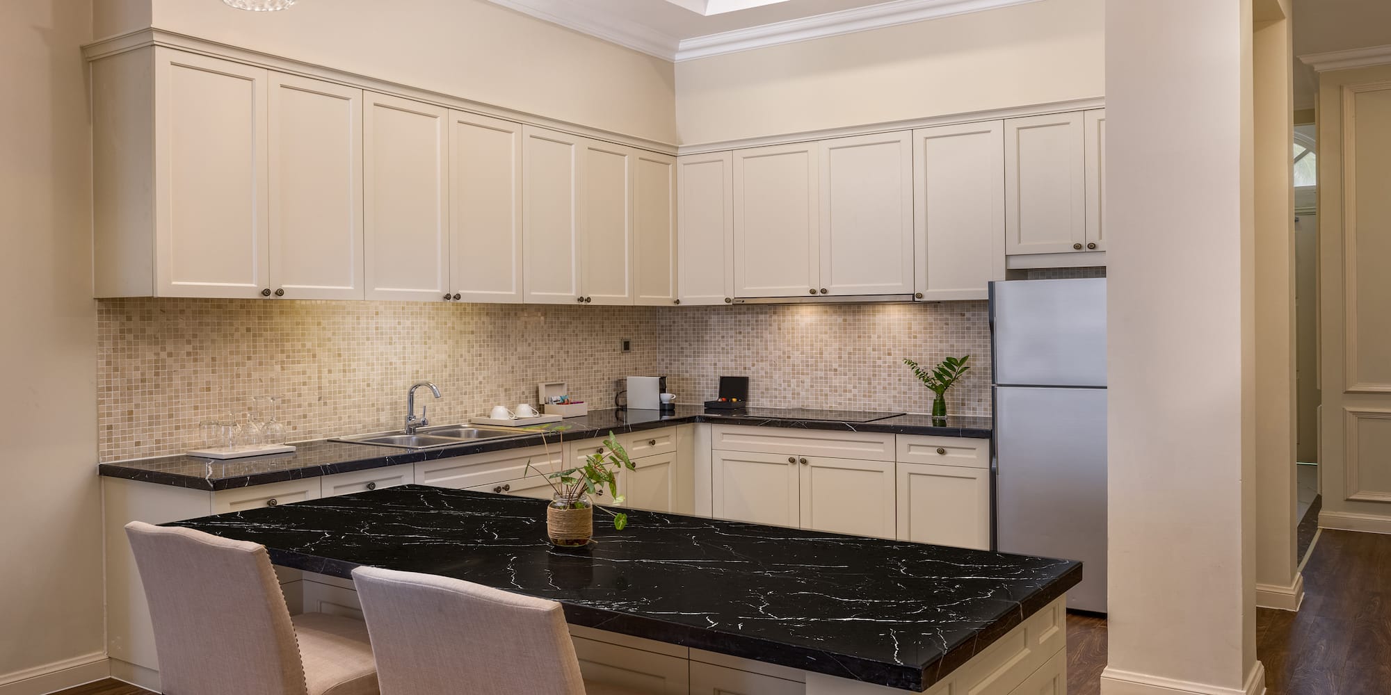 a kitchen with a black countertop and chairs