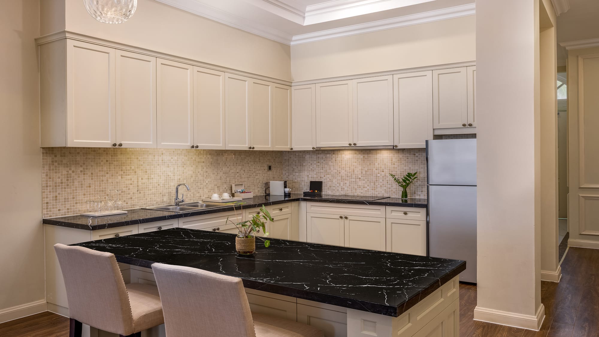 a kitchen with a black countertop and chairs
