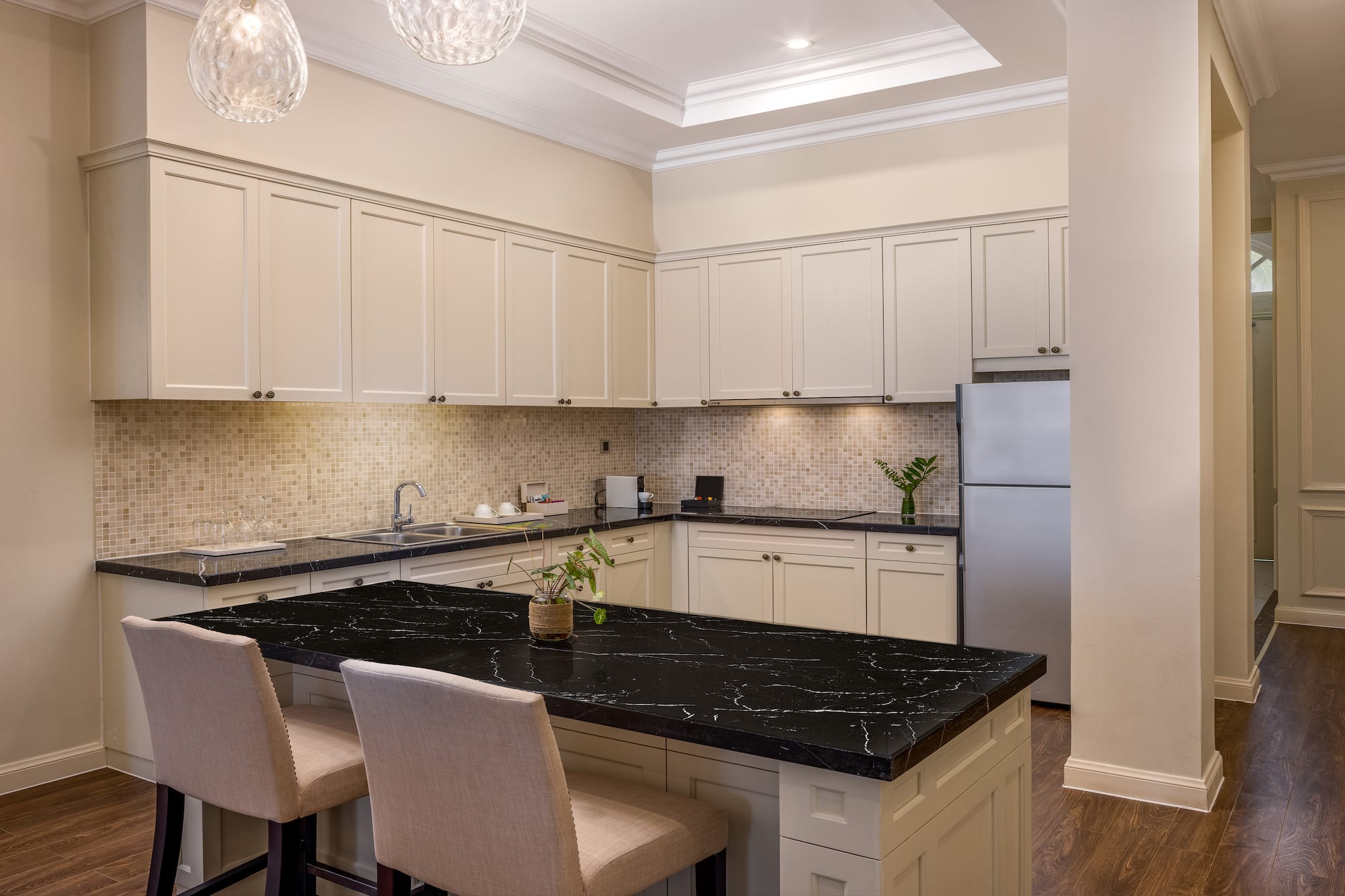 a kitchen with a black countertop and chairs