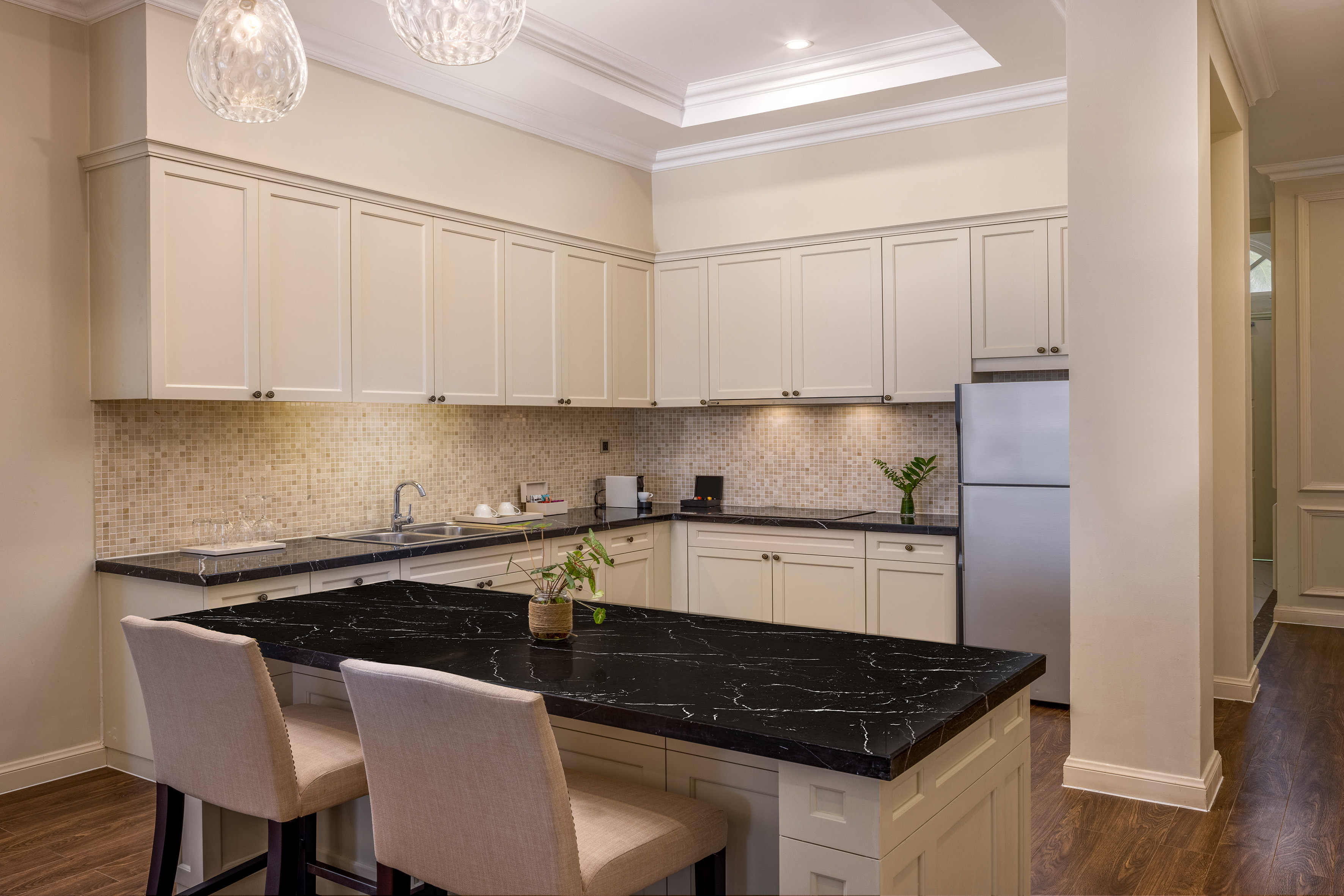 a kitchen with a black countertop and chairs