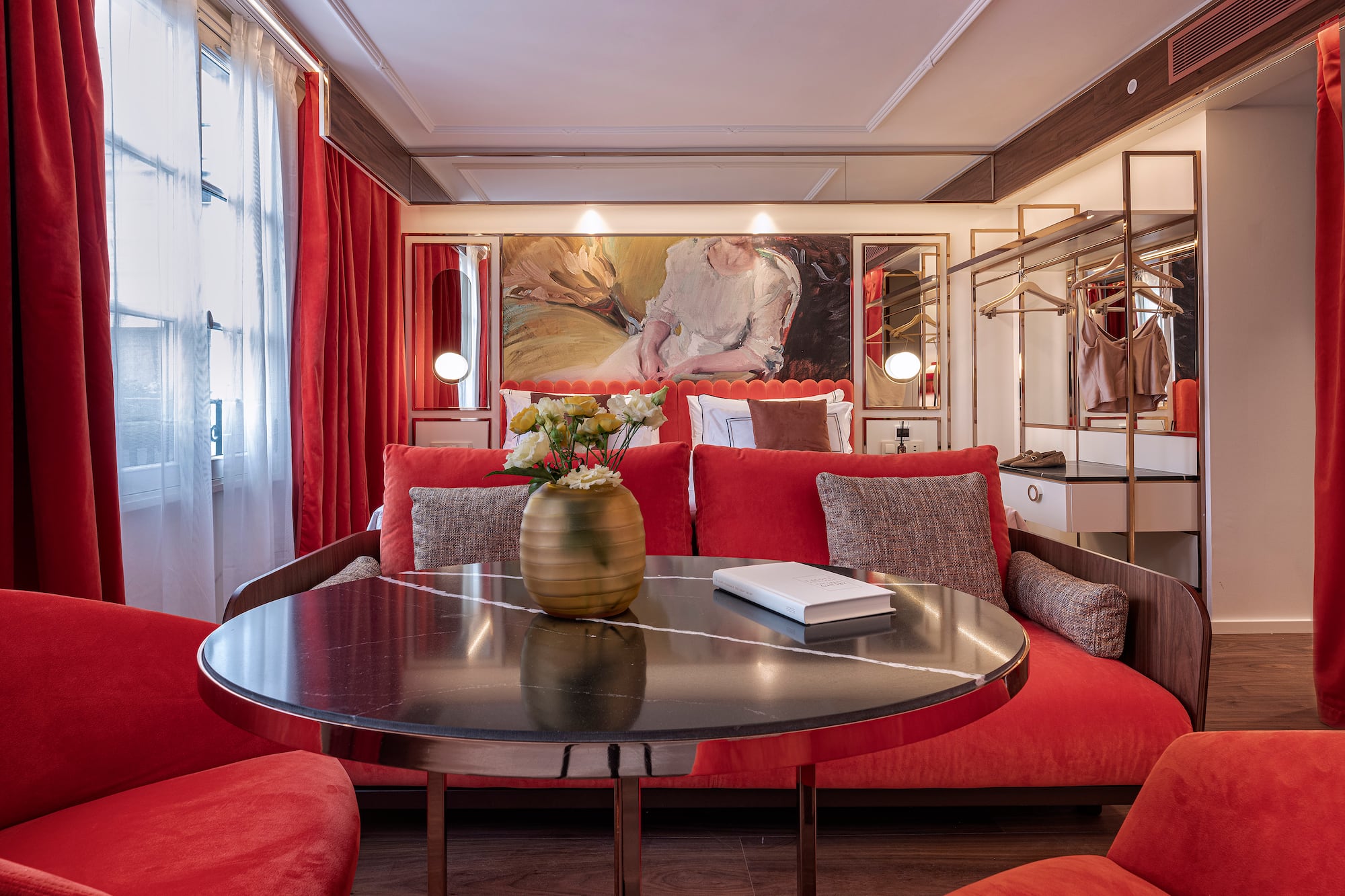 a room with red couches and a table with a vase of flowers