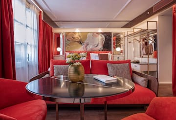 a room with red couches and a table with a vase of flowers