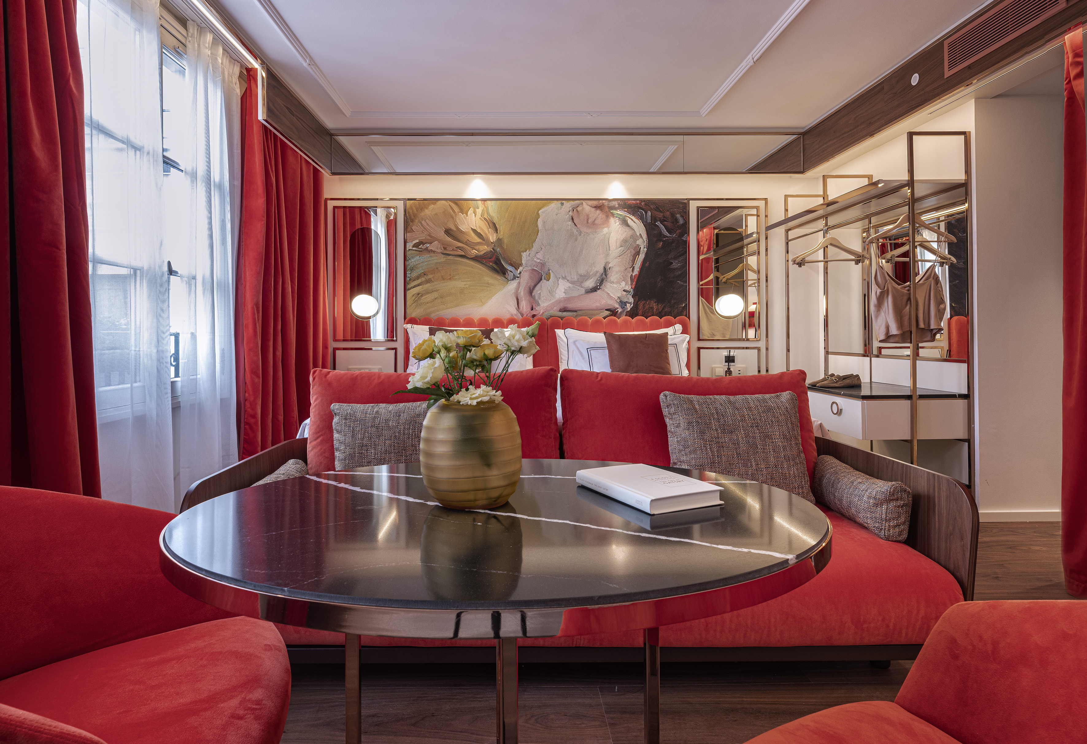 a room with red couches and a table with a vase of flowers