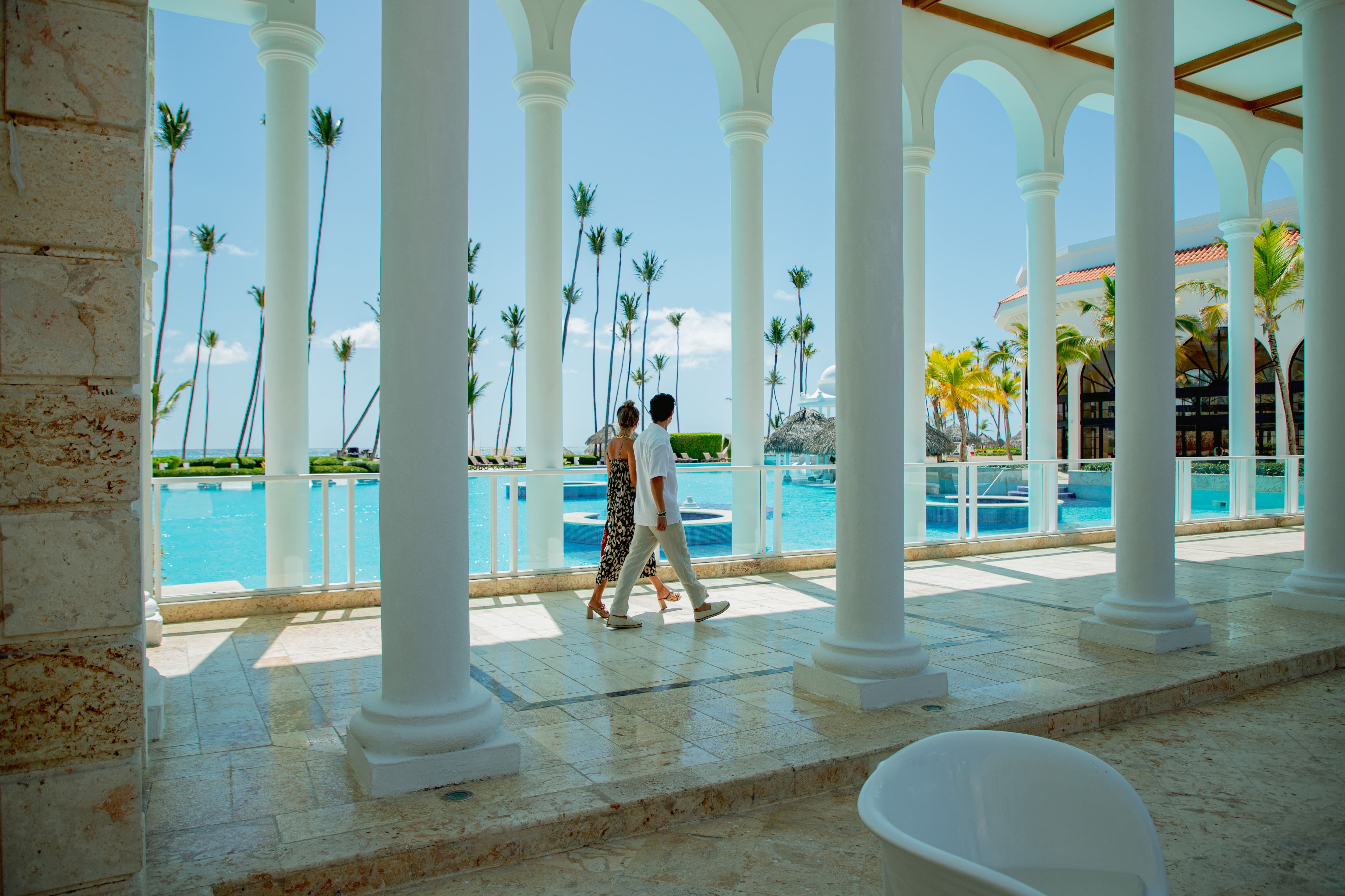 a man and woman walking by a pool