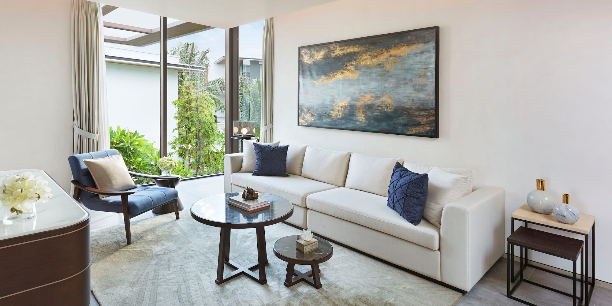a living room with a white couch and blue pillows