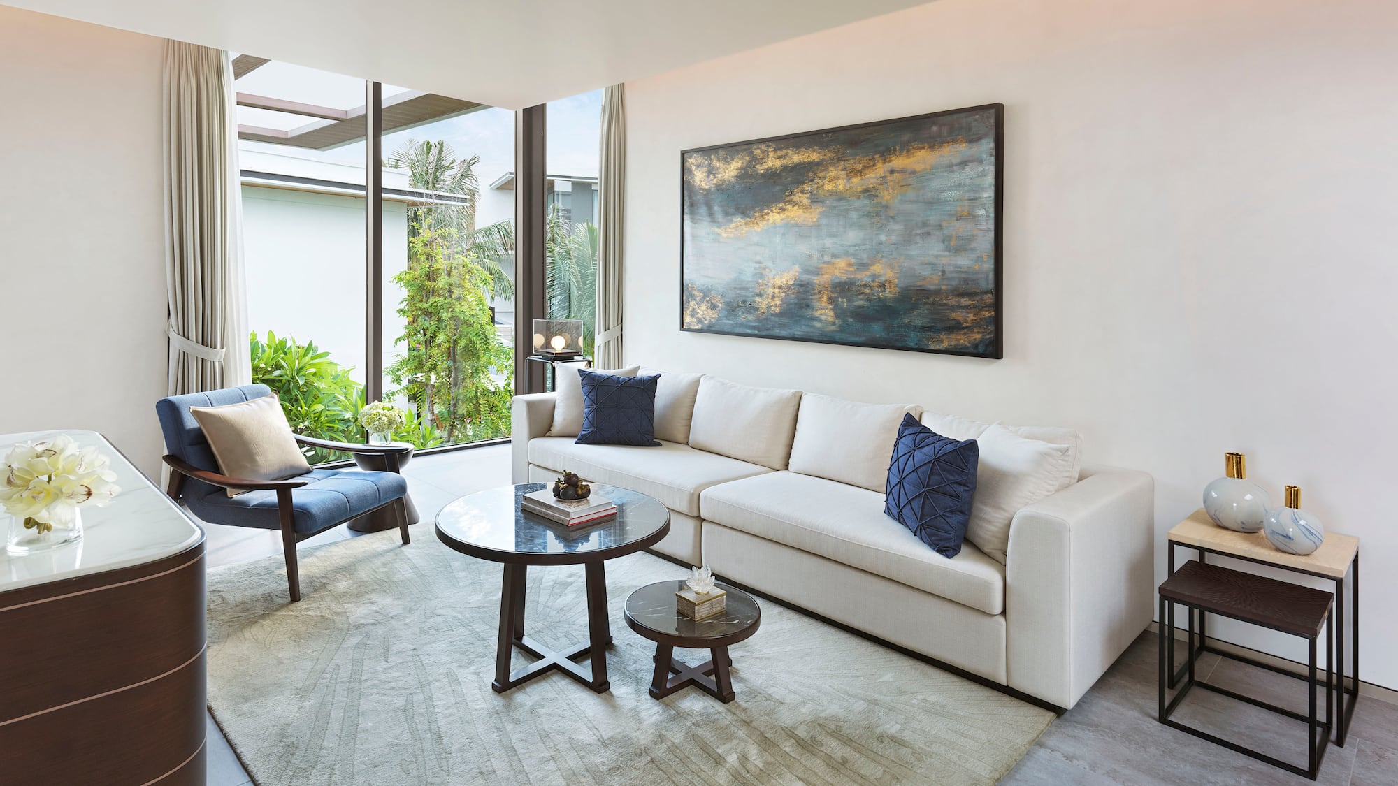 a living room with a white couch and blue pillows