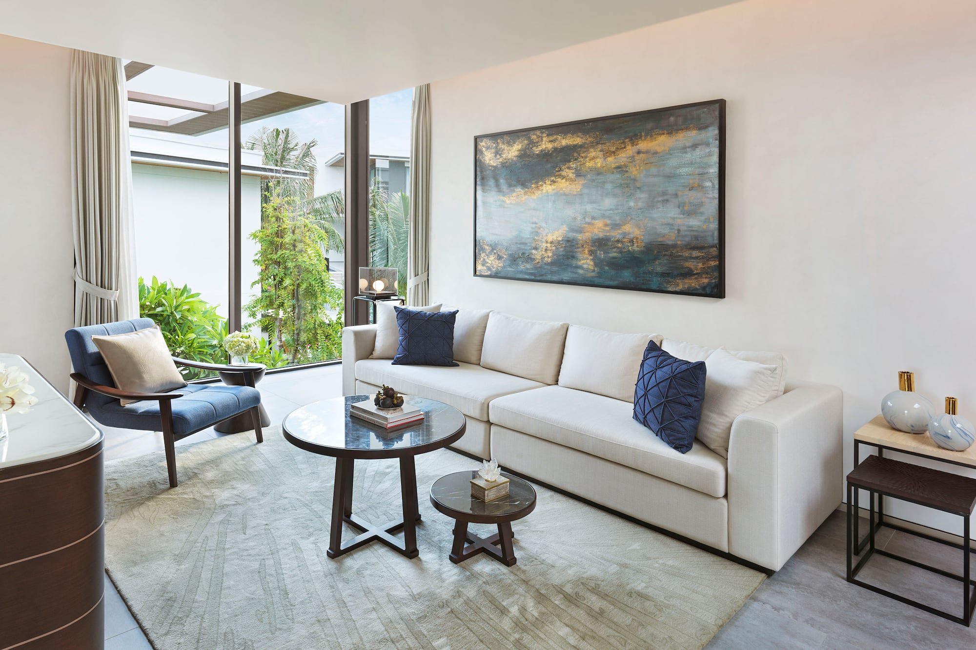 a living room with a white couch and blue pillows