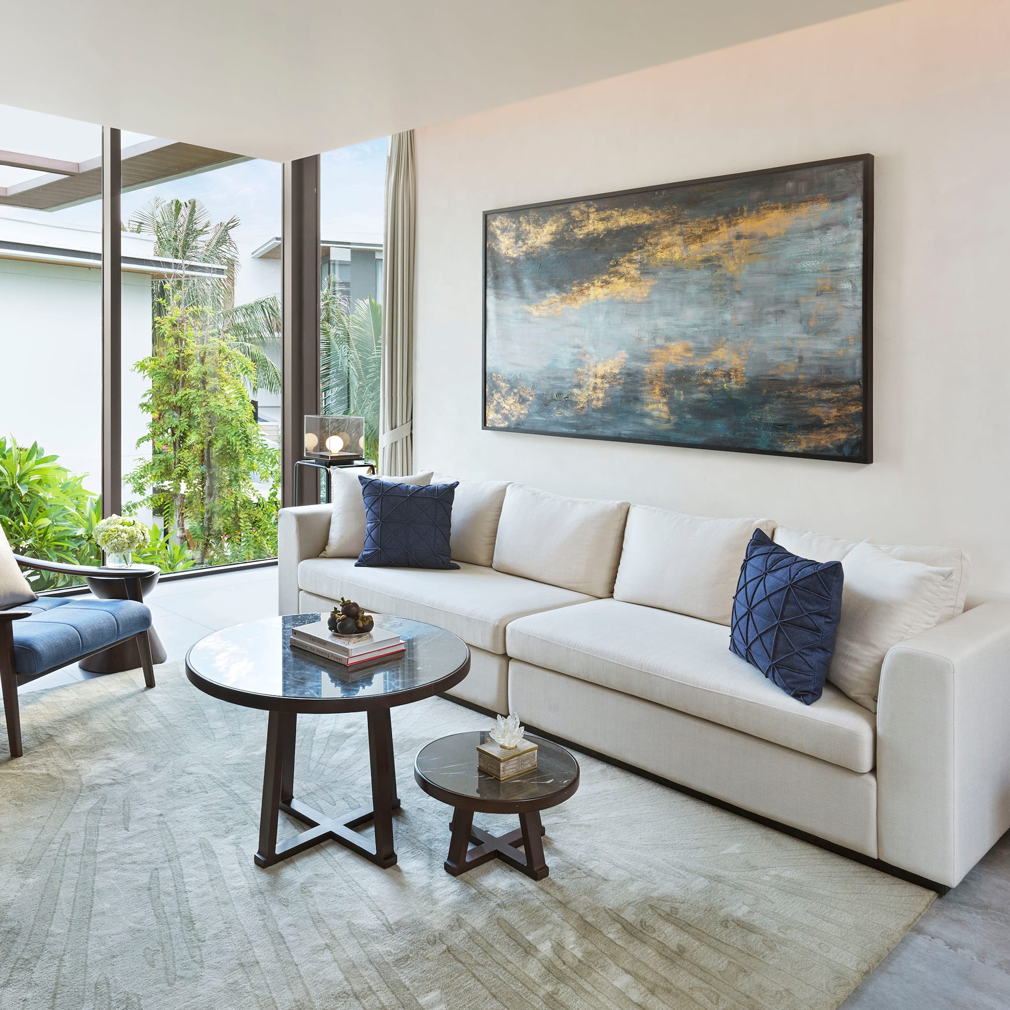 a living room with a white couch and blue pillows