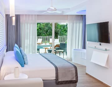 a bedroom with a large bed and a tub