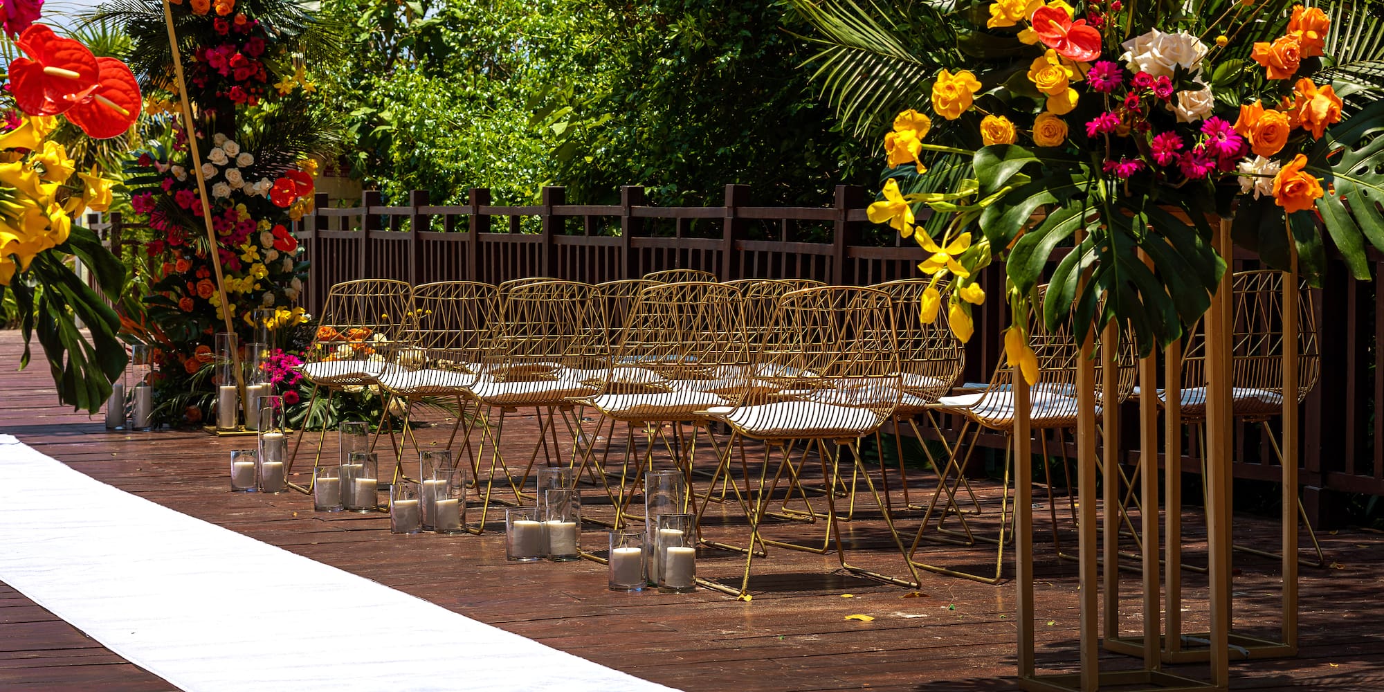 a row of chairs and flowers on a wooden surface