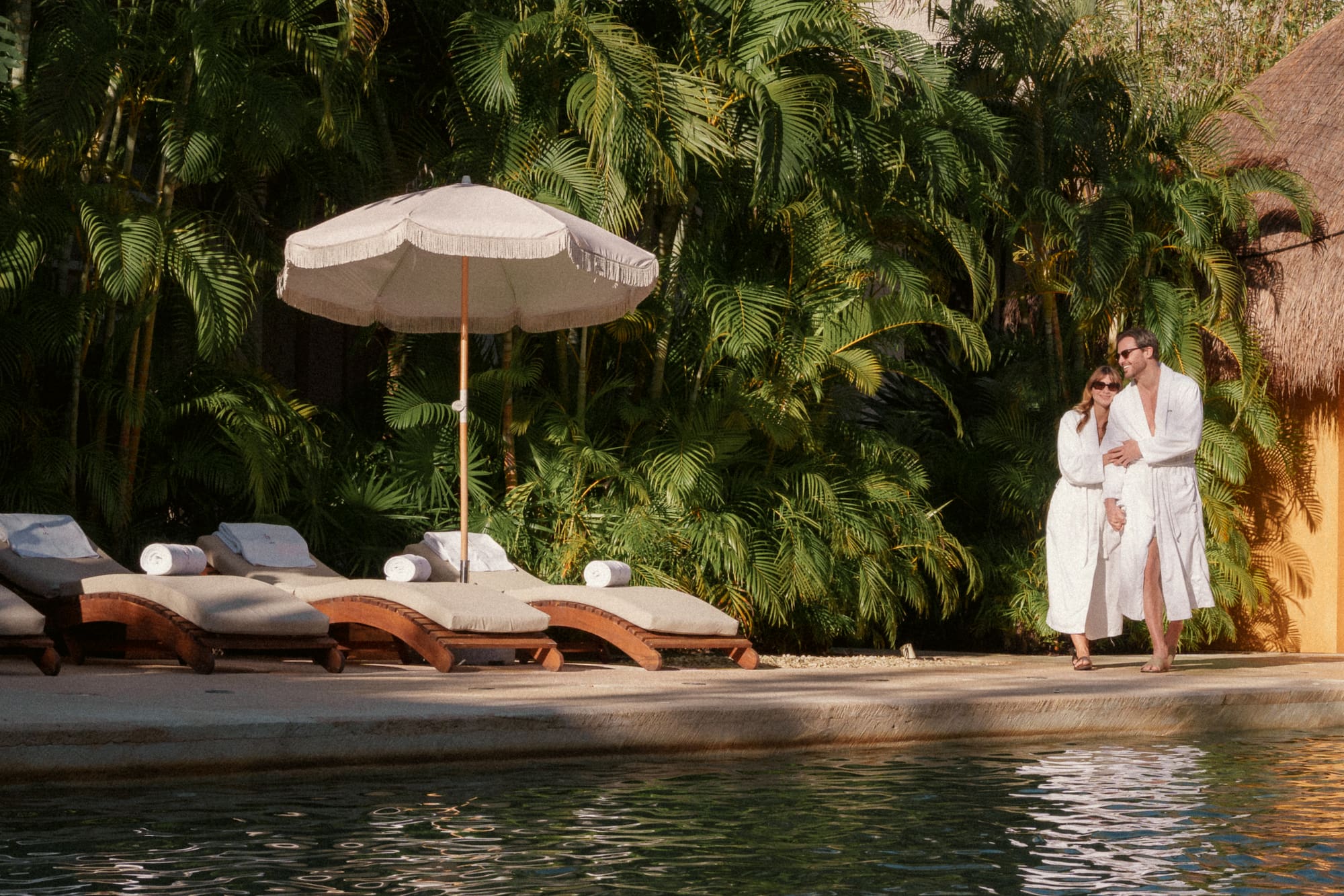 a woman holding a baby by a pool