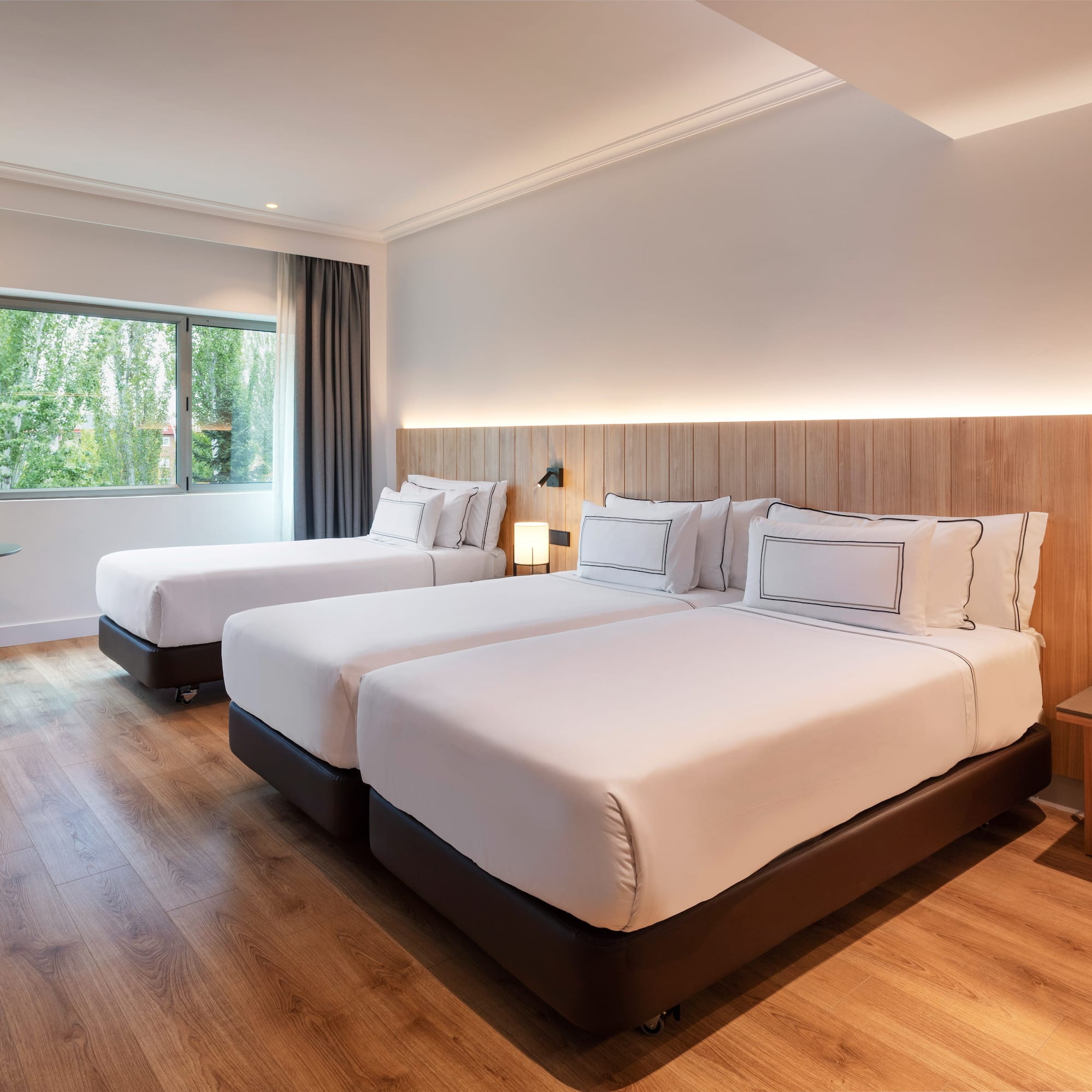 a room with two beds and a wood floor