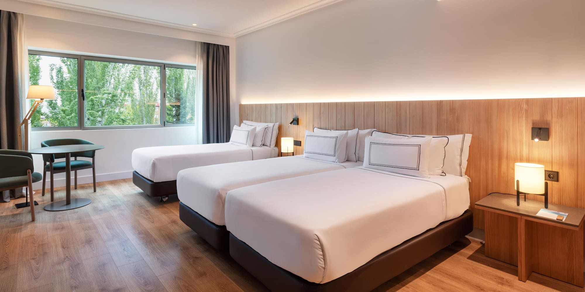 a room with two beds and a wood floor