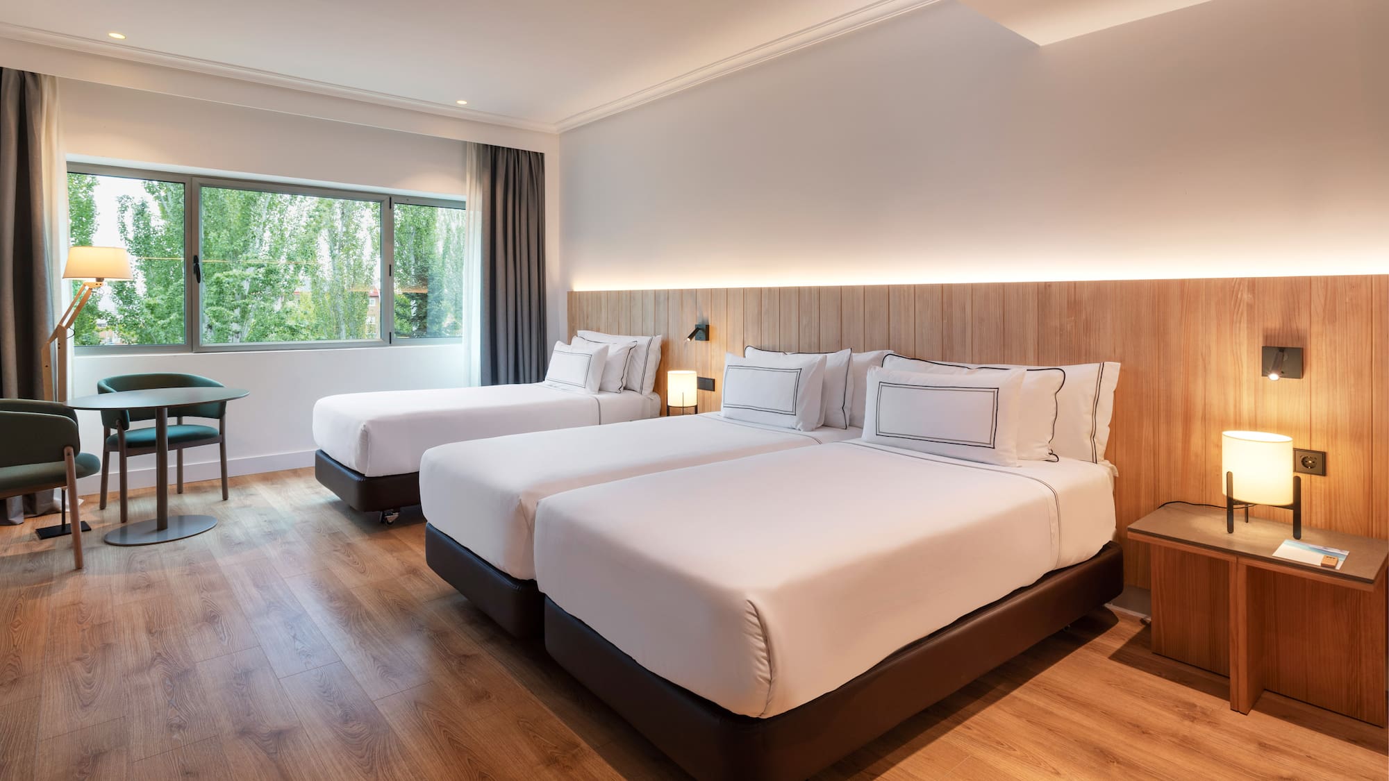 a room with two beds and a wood floor