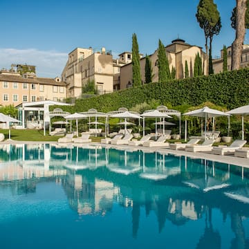 a pool with umbrellas and chairs in front of a building
