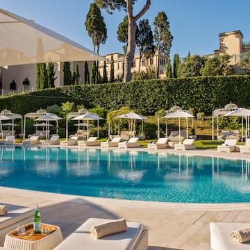 a pool with lounge chairs and umbrellas
