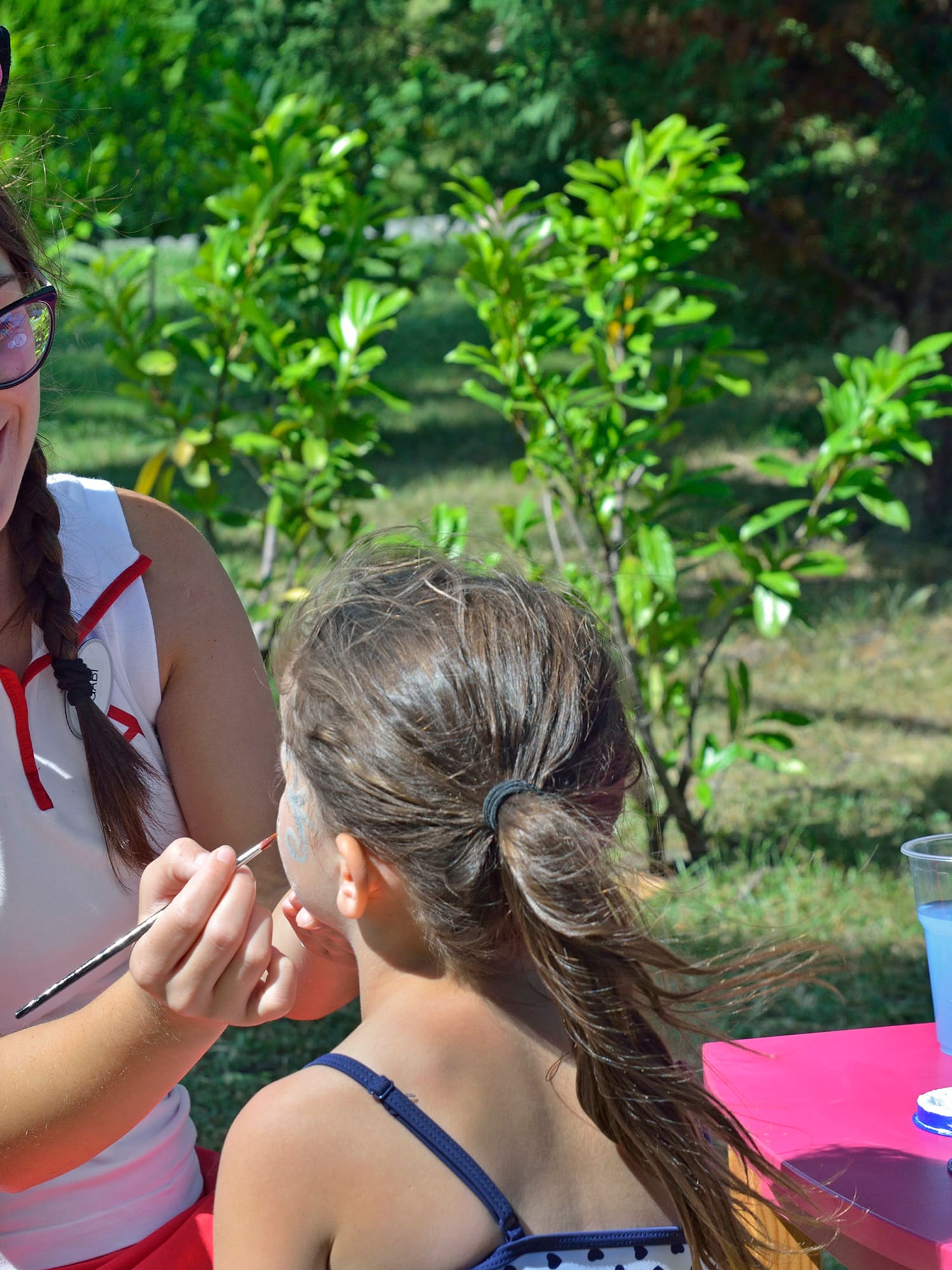 a woman painting a girl's face