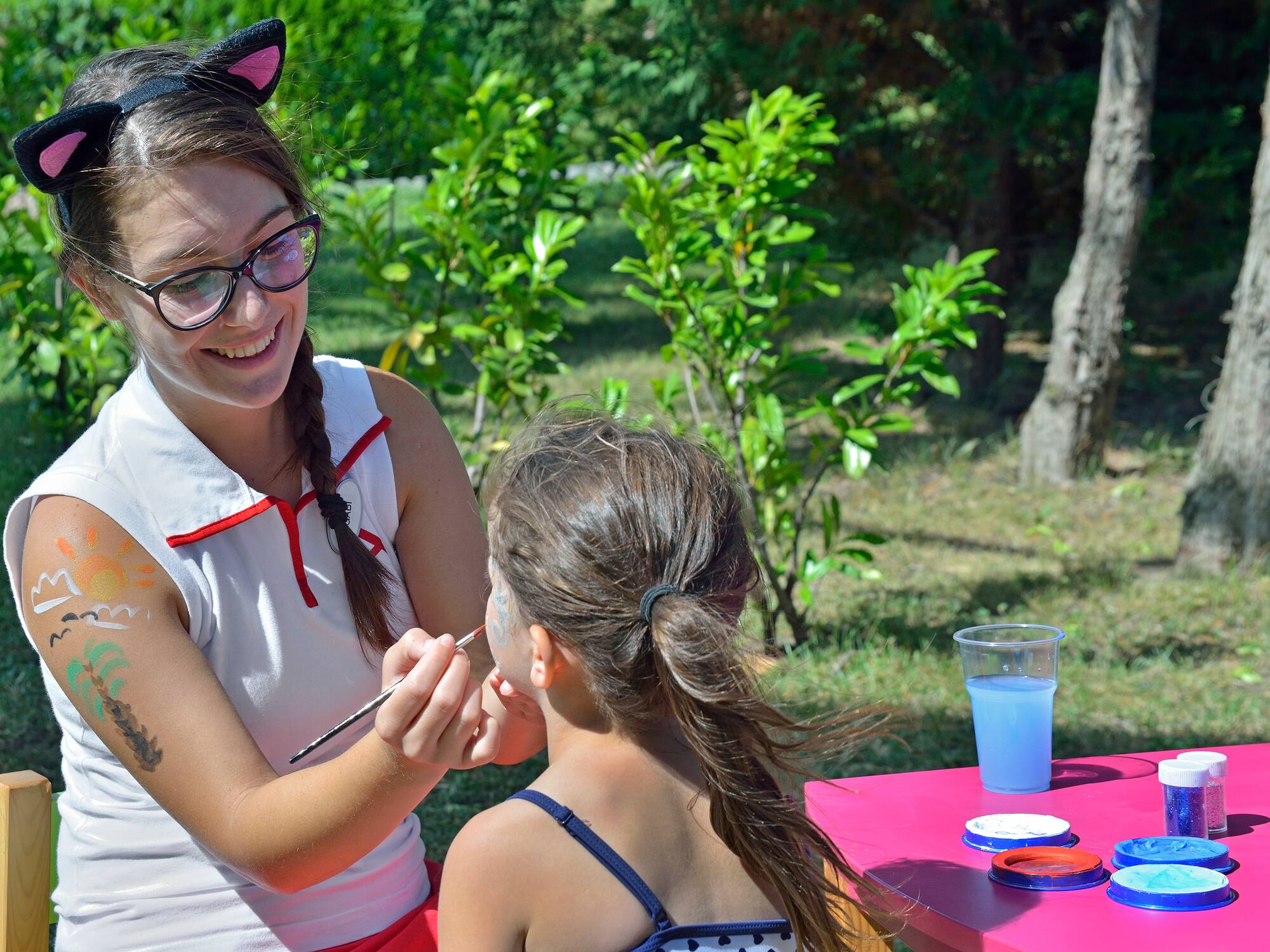 a woman painting a girl's face