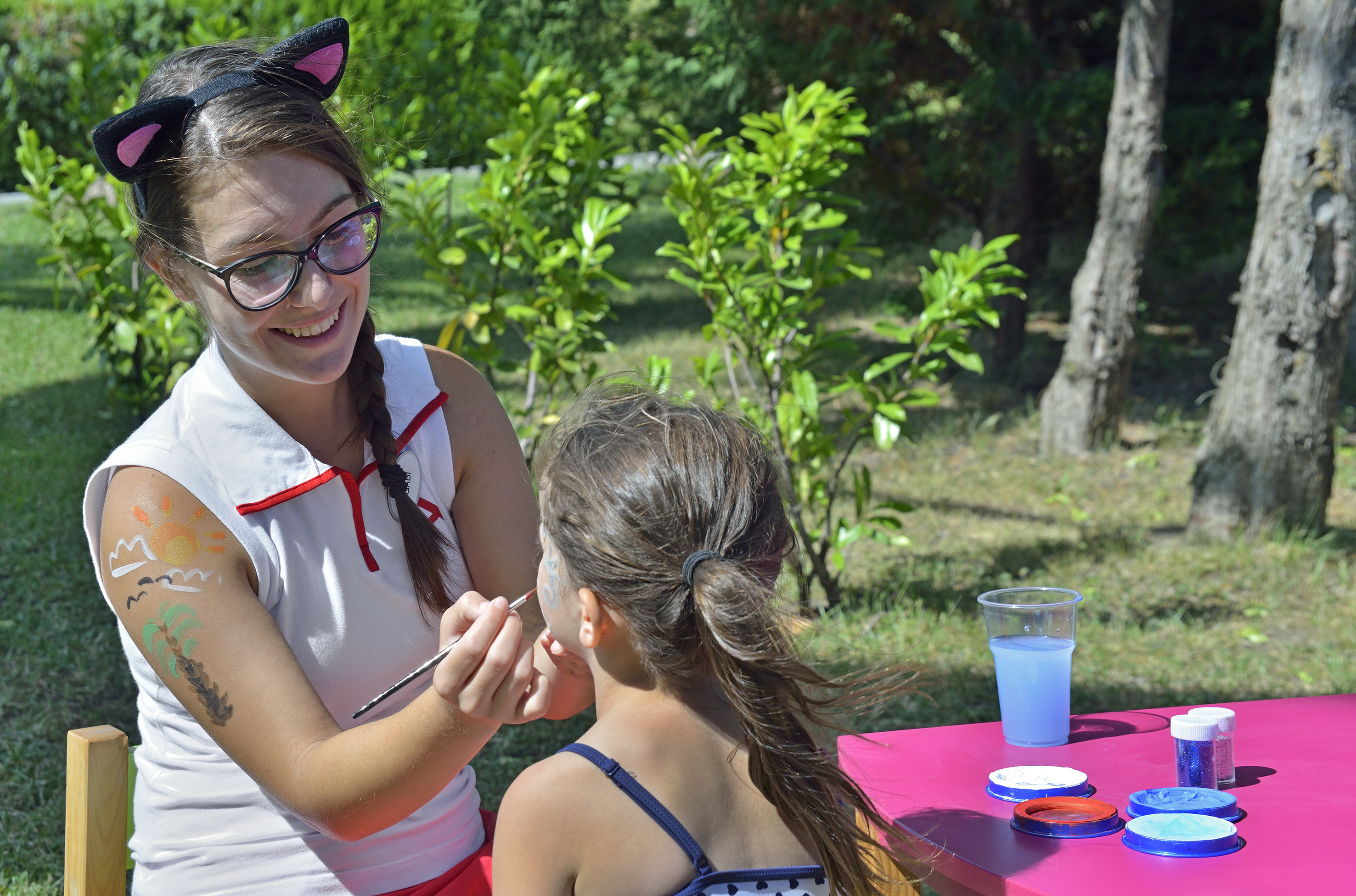 a woman painting a girl's face