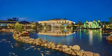 a pond with a building and fish swimming in it