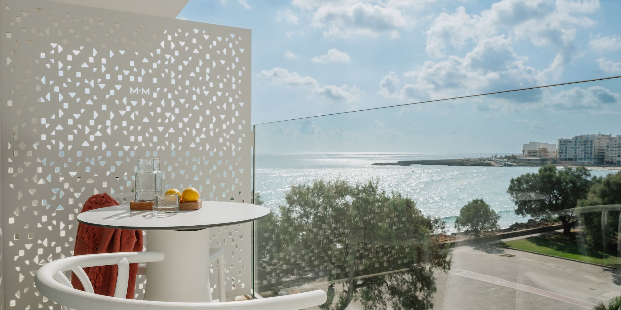a table and chairs with a view of the ocean