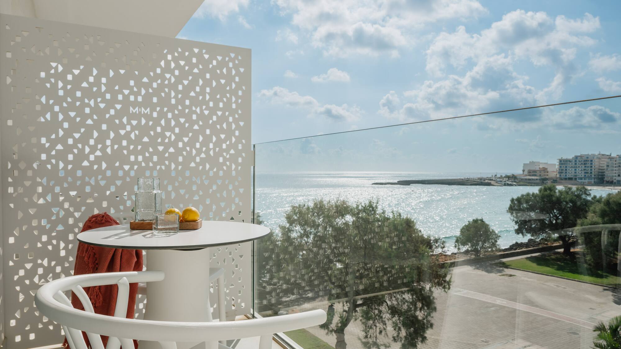 a table and chairs with a view of the ocean