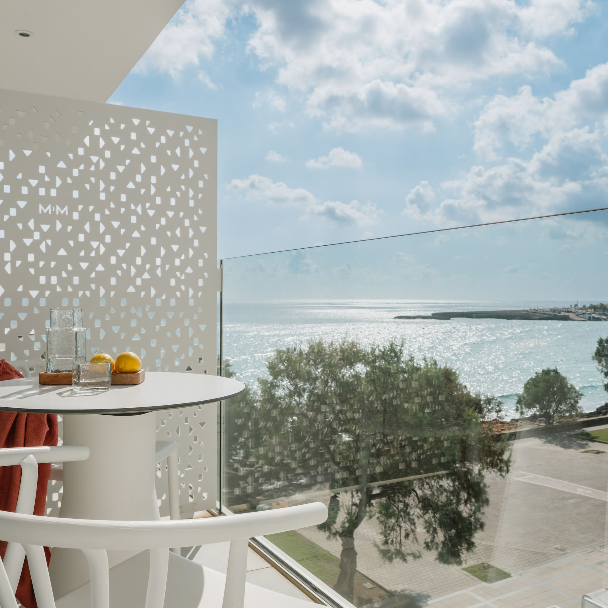 a table and chairs with a view of the ocean