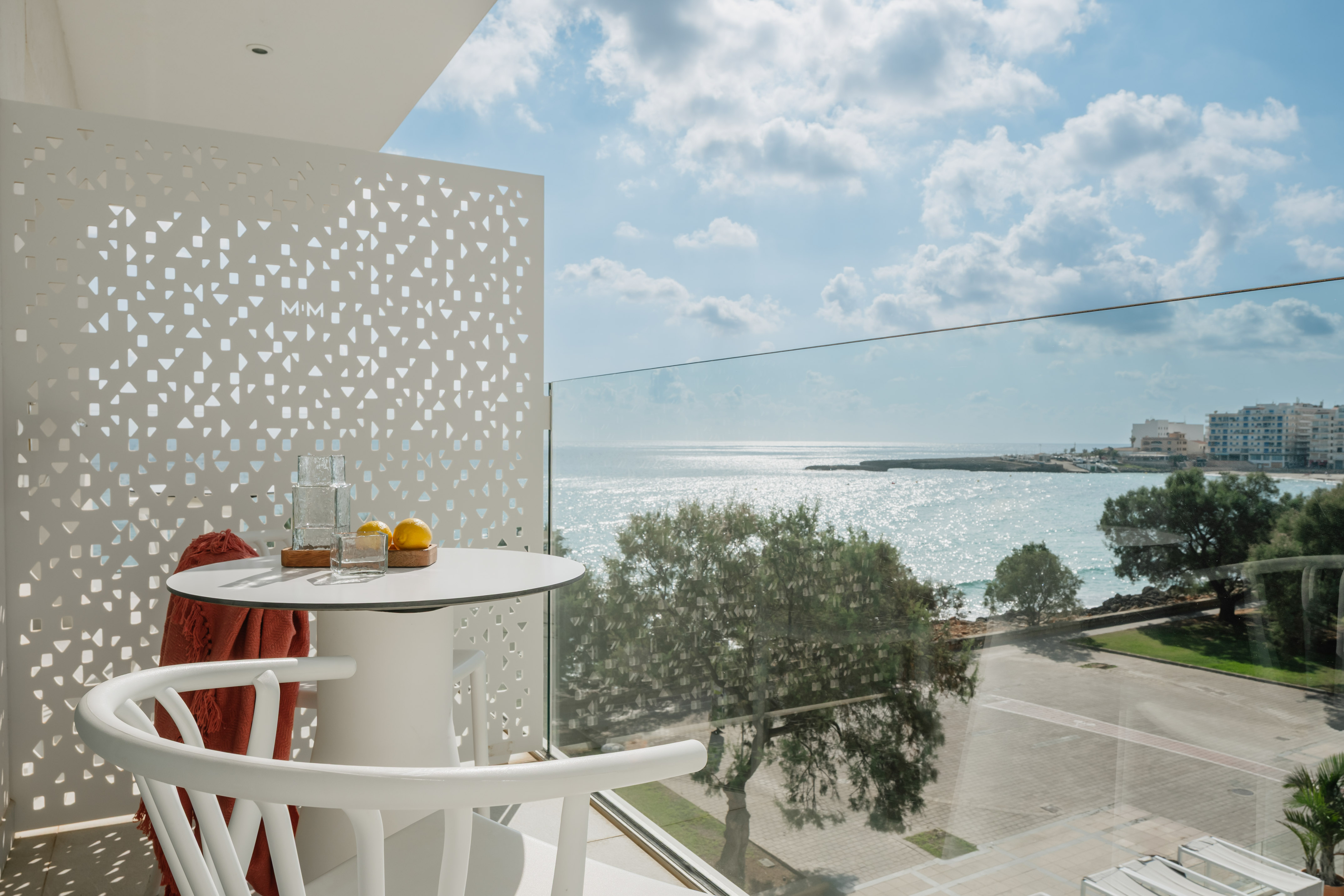 a table and chairs with a view of the ocean