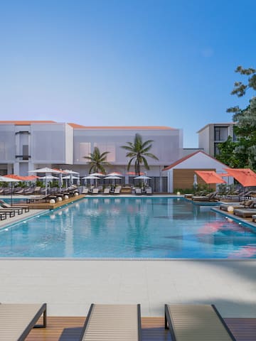 a pool with umbrellas and chairs in front of a building
