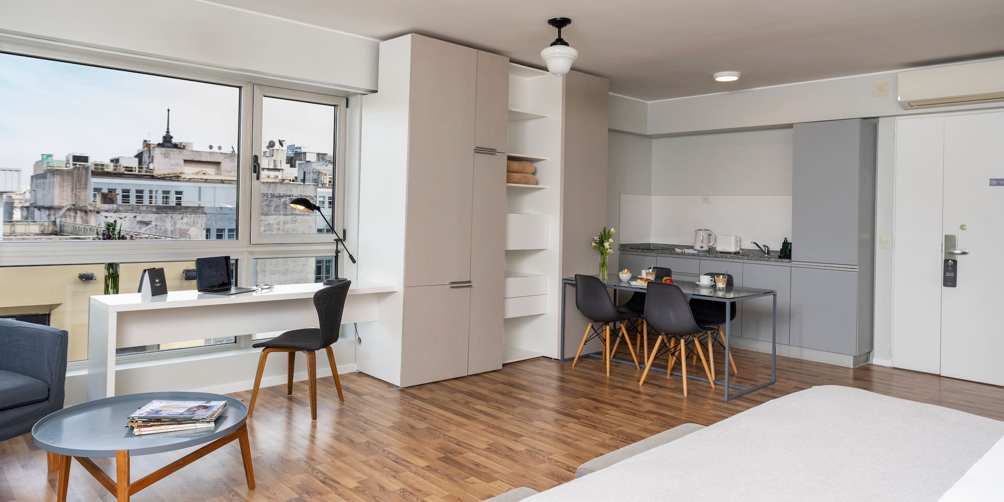 a room with a bed and a table and chairs